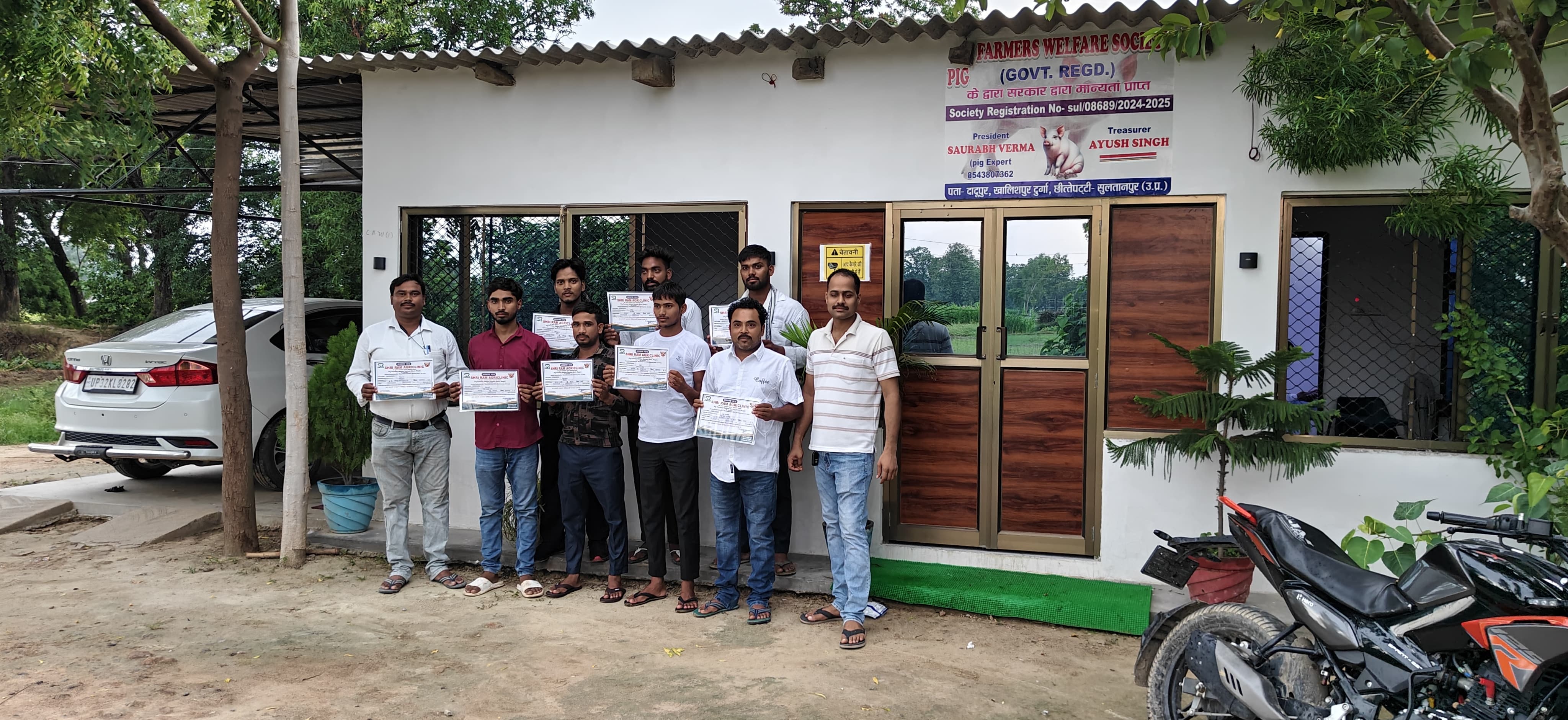 कक्षा के अंदर अपने आधिकारिक रूप से हस्ताक्षरित प्रमाणन प्रतियां लिए हुए सफल सुअर पालन प्रशिक्षु
